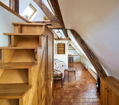 Cette chambre mansardée dispose d'étagères en bois et d'un escalier. dans l'établissement Saint Germain Flat, à Paris