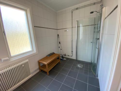 a bathroom with a shower and a tile floor at Vandrarhemmet Hörneborg in Örnsköldsvik