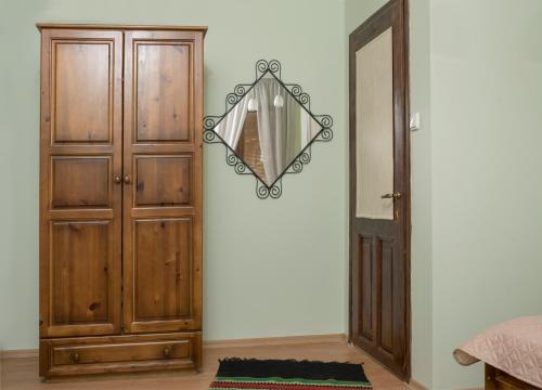 a bedroom with a mirror next to a wooden cabinet at The Sunny Guest House of Veliko Tarnovo-Amazing View, Top Location in Veliko Tŭrnovo