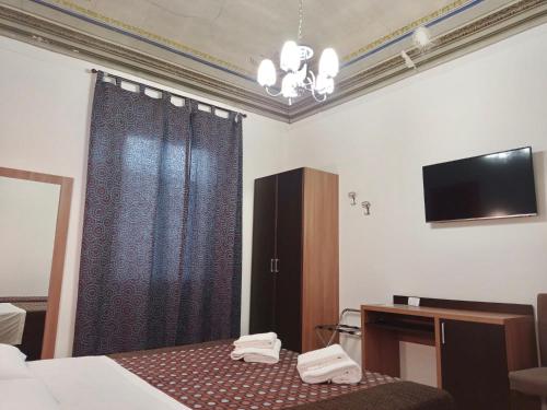 フィレンツェにあるAdelaide Houseのベッドとテレビが備わるホテルルームです。