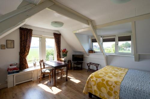 a bedroom with a bed and a desk and windows at B&B Landleven in Hellevoetsluis