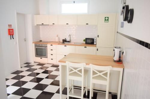 cocina con mesa y sillas y suelo a cuadros en Casa D`Avó Joana, en Ponta Delgada