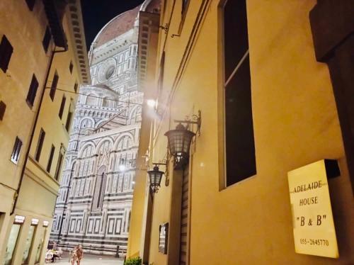 un bâtiment avec deux lumières sur le côté d'une rue dans l'établissement Adelaide House, à Florence