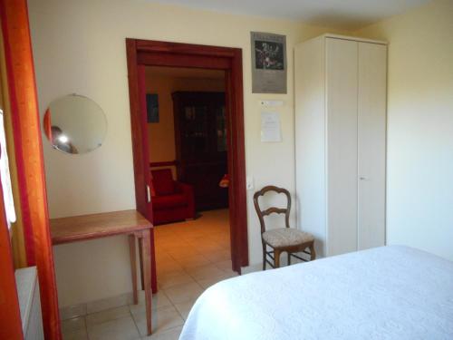 MeyralsにあるGîte La Jaubertie Labellisé Handicapのベッドルーム1室(ベッド1台、椅子、鏡付)