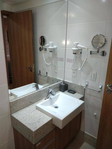 a bathroom with a sink and a mirror at Suíte Charmosa em Pedra Azul in Pedra Azul