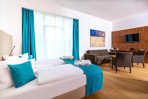 a hotel room with a bed and a living room at Hotel an der Therme Bad Sulza in Bad Sulza