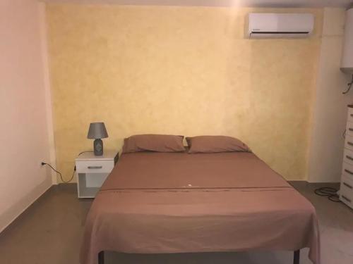ein Schlafzimmer mit einem Bett und einer Lampe auf einem Nachttisch in der Unterkunft Casa Casteldaccia 3 in Casteldaccia