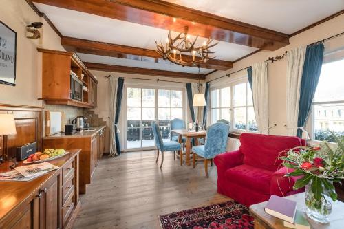 a living room with a red couch and a table at Villa Orania in Bad Gastein