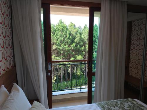 a bedroom with a door open to a balcony at Suíte Charmosa em Pedra Azul in Pedra Azul