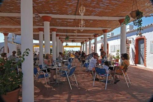 a group of people sitting at tables on a patio at Pedras D'el Rei - Vista Ria in Tavira