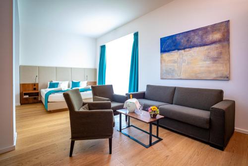 a living room with a couch and chairs and a bed at Hotel an der Therme Bad Sulza in Bad Sulza