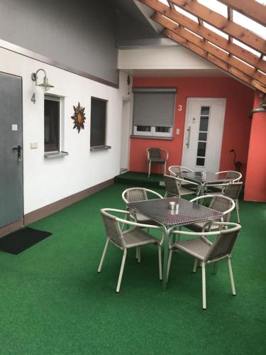 un grupo de mesas y sillas en un suelo verde en Gästehaus Durst, en Rust