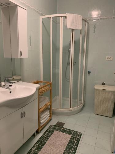 une salle de bain avec douche et lavabo dans l'établissement Apartma Piran, à Piran