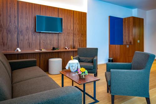 a waiting room with two chairs and a tv at Hotel an der Therme Bad Sulza in Bad Sulza