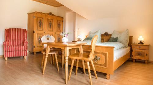 a bedroom with a bed with a table and a chair at Ferienhaus Mehlhartl in Tamsweg