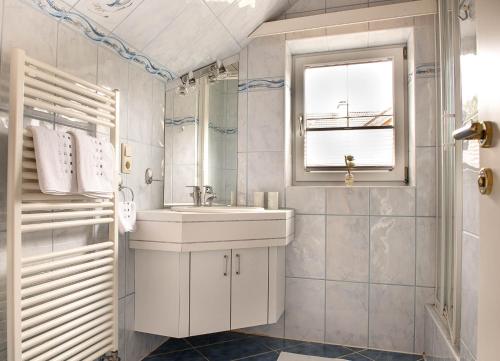 a white bathroom with a sink and a window at Ferienhaus Mehlhartl in Tamsweg