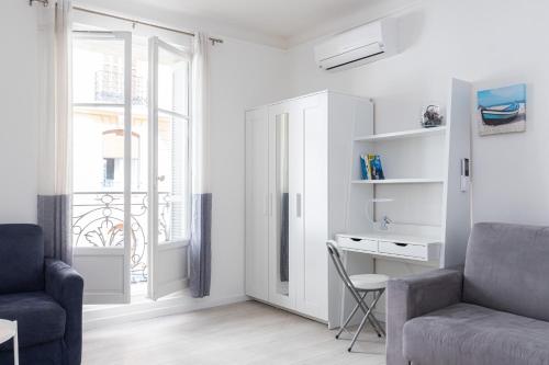 un salon avec une chaise, un bureau et une fenêtre dans l'établissement Promenade des Anglais . Nice, à Nice