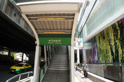 a woman walking down a stairs in a building at Arawana Residence Phromphong in Khlong Toei
