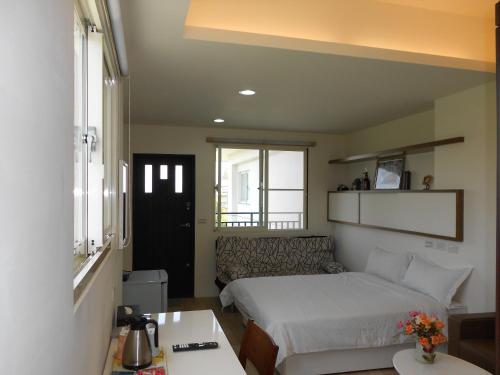 a small bedroom with a bed and a table at 蘭卡威羅東庭園民宿 in Luodong