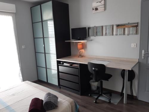 BraxChambre d'hôtes Les Joncs的客房配有书桌和带书桌的床。