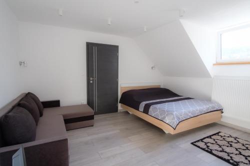 a bedroom with a bed and a couch at Villa Zarra in Habovka