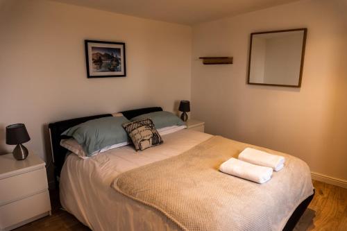 a bedroom with a bed with two towels on it at Culbokie Lodges in Culbokie