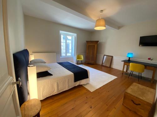 um quarto com uma cama, uma mesa e cadeiras em Le Durivum em Montaigu-Vendée