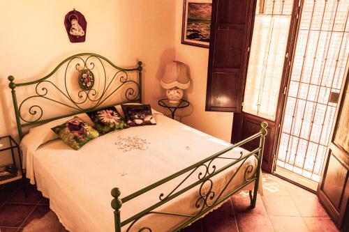 ein Schlafzimmer mit einem Bett mit einem grünen Rahmen in der Unterkunft Agriturismo Il Marrucheto in Scala Santa