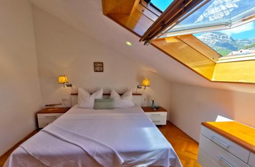 a bedroom with a large bed with a large window at Villa Mira in Bol