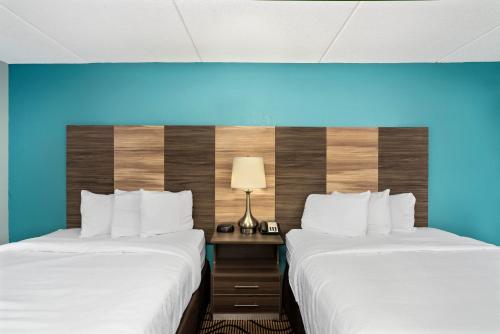 two beds in a hotel room with a blue wall at La Quinta by Wyndham Sevierville / Kodak in Sevierville