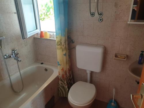 a bathroom with a toilet and a tub and a sink at Apartments & Rooms Zlatica Hvar in Hvar