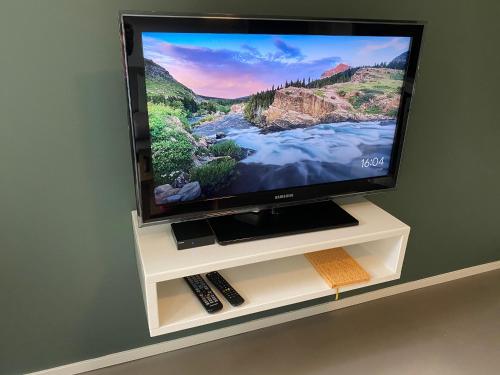 a flat screen tv sitting on a white entertainment center at Appartement Duinweg in Onstwedde