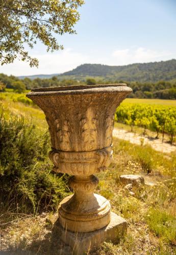 a stone vase sitting in the middle of a field at Le Mas Sérénité in Ansouis