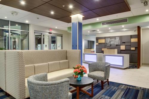 a living room filled with furniture and a tv at Holiday Inn Express & Suites Galesburg, an IHG Hotel in Galesburg