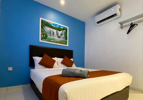 1 dormitorio con 1 cama con pared azul en Hotel EC Double Star KLIA 1-KLIA 2 en Sepang