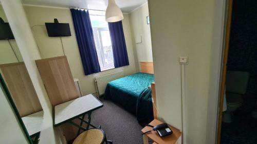 een kleine kamer met een bed en een raam bij hotel Melissa in Péruwelz