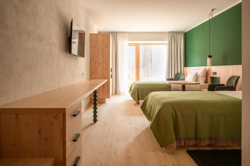 a hotel room with two beds with green walls at Hotel Neusacherhof in Weissensee