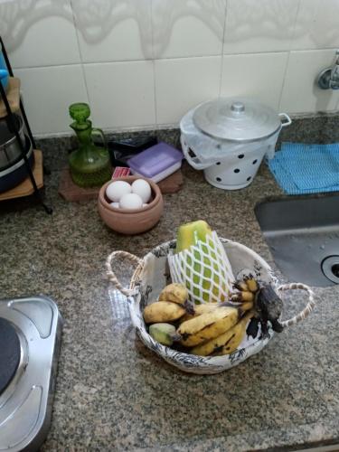 a basket of bananas and eggs on a kitchen counter at Eco Chalés Águas Claras in Lumiar