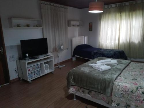 a bedroom with two beds and a flat screen tv at Eco Chalés Águas Claras in Lumiar