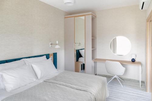 a bedroom with a bed and a chair and a mirror at Hotel Morski Widok in Krynica Morska