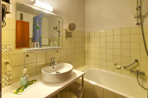 a bathroom with a sink and a bath tub at Hotel Bären in Bad Krozingen