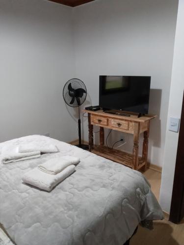 a bedroom with a bed and a tv and a table at Eco Chalés Águas Claras in Lumiar