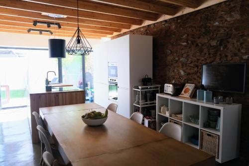 a dining room with a table and a television at Casa da Ribeira Guesthouse in Alvares