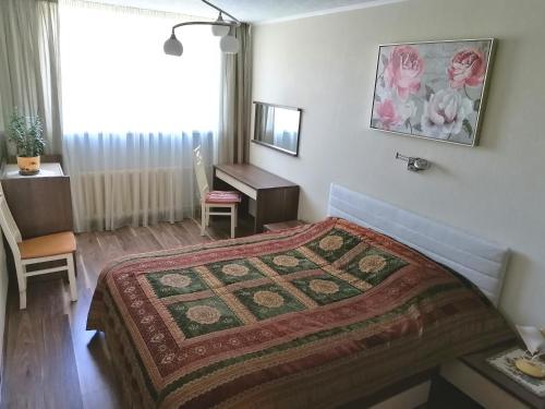 a bedroom with a bed and a desk and a window at Baltic Dreams 2 in Jūrmala