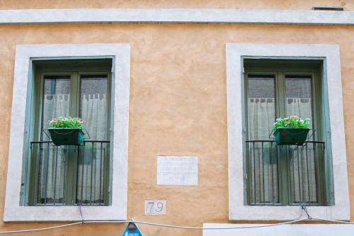 two windows with flower pots on them on a building at Campo dé Fiori - Apt 2 in Rome
