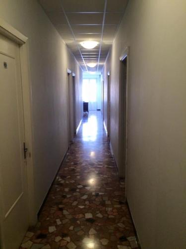 a long hallway with a tile floor and a hallway with a door at Albergo Magenta in Casella