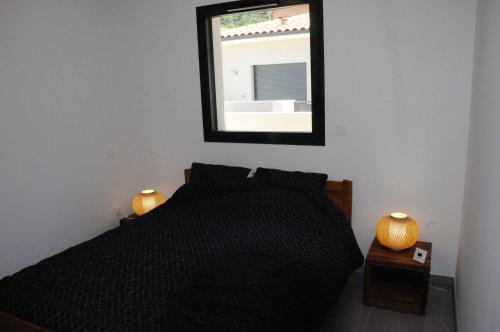 Schlafzimmer mit einem schwarzen Bett und einem Spiegel in der Unterkunft Appartement avec grande terrasse vue sur mer in Banyuls-sur-Mer