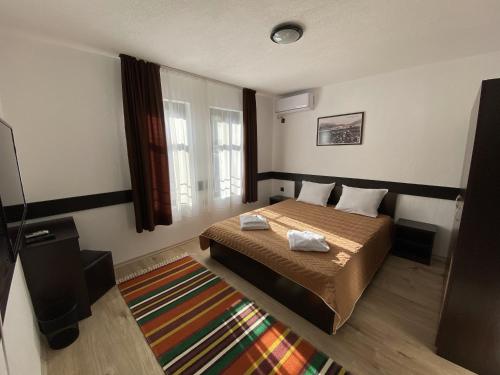 1 dormitorio con 1 cama con 2 toallas en Апартхотел "Старият Град" в етнографски комплекс en Zlatograd