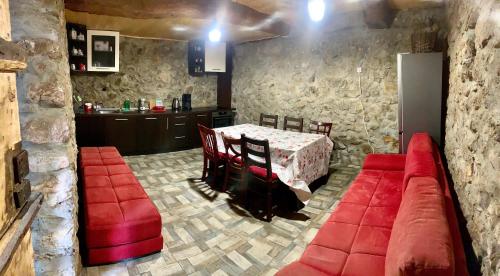 a living room with a red couch and a table at Цяла Ваканционна Къща- Florina Houses in Goranovtsi