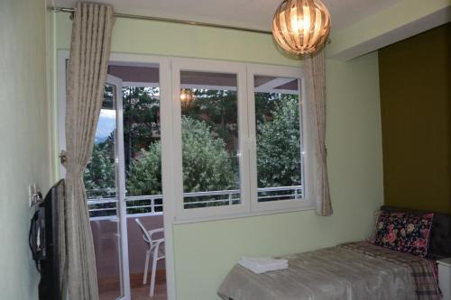 a bedroom with a bed and a window with a view at Royal Hotel Peshkopi Albania in Peshkopi